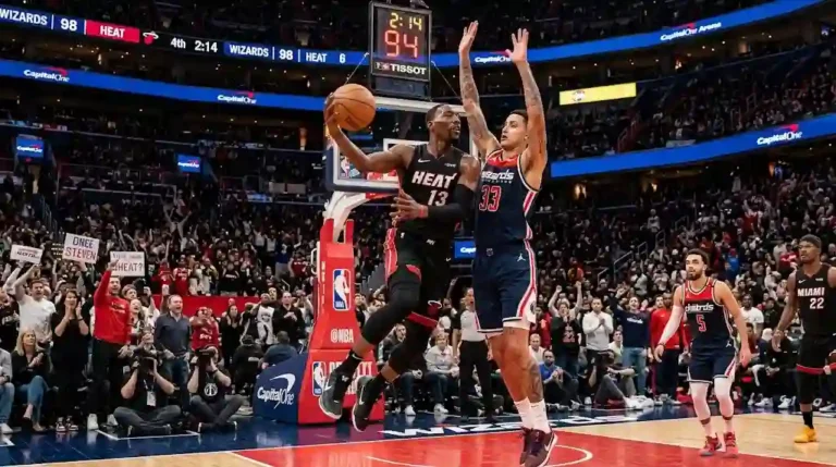Miami Heat player driving to the basket while contested by a Washington Wizards defender during a high-stakes NBA game in a packed arena.